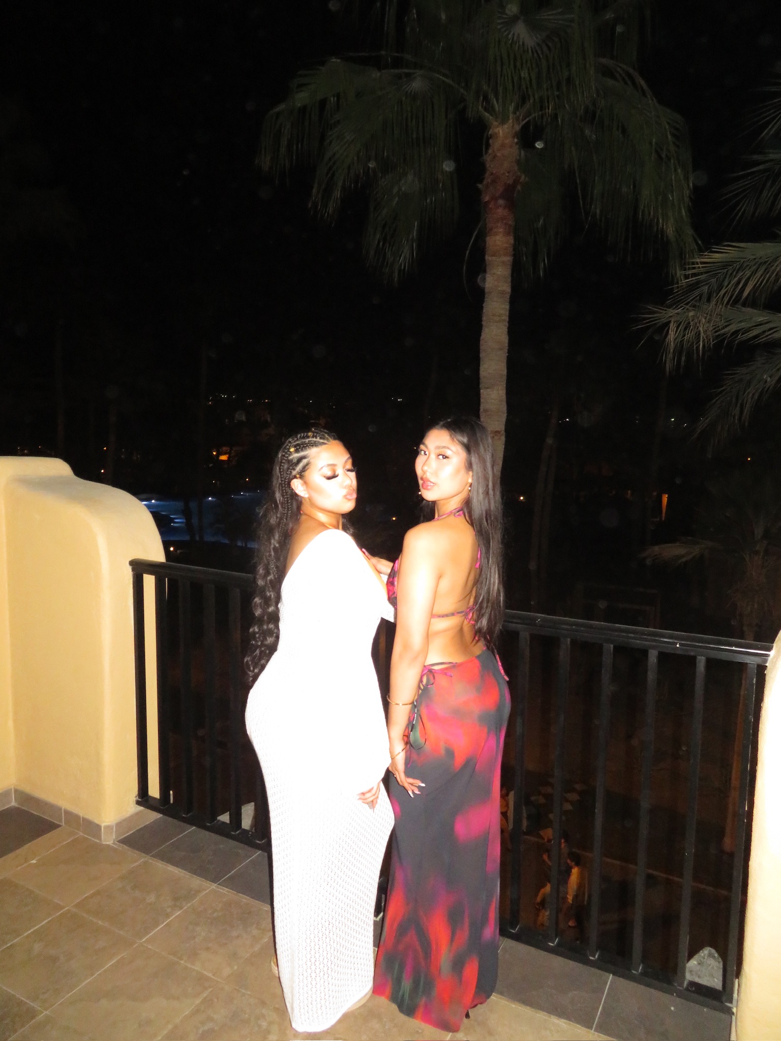 Two friends on a balcony at night